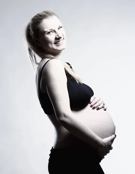 Blond Kobieta w ciąży w Bra czarny. — Zdjęcie stockowe