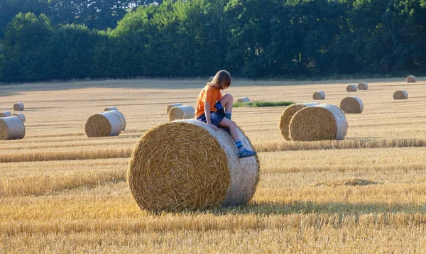 Boy Sitting on a Bale of Hay — Stock Photo, Image