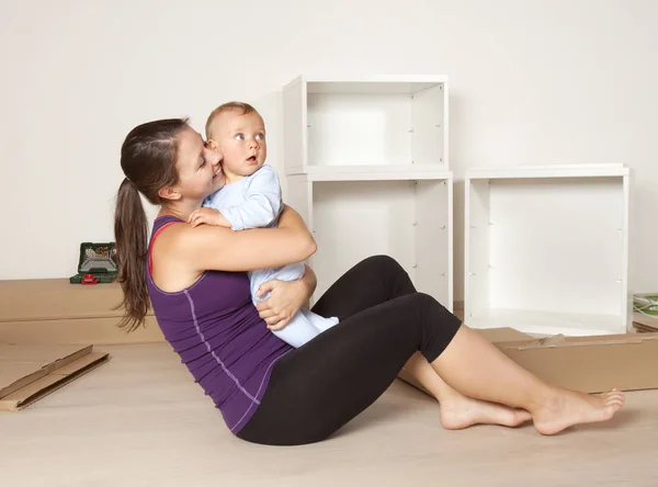 Junge Mutter mit Baby zieht in neue Wohnung — Stockfoto