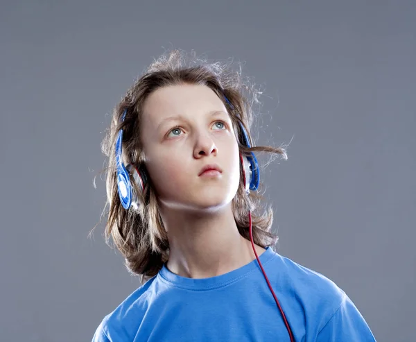 Niño con el pelo castaño escuchando música en auriculares . —  Fotos de Stock