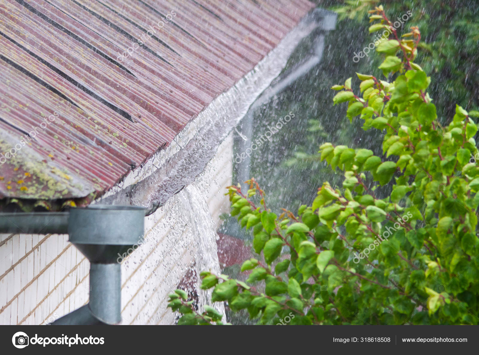 Closeup of leaking rain gutter overflowing with water during the rain