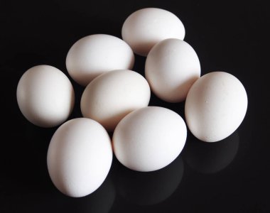Karanlık bir arka plan üzerinde beyaz yumurta tavuk