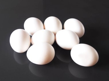 Karanlık bir arka plan üzerinde beyaz yumurta tavuk