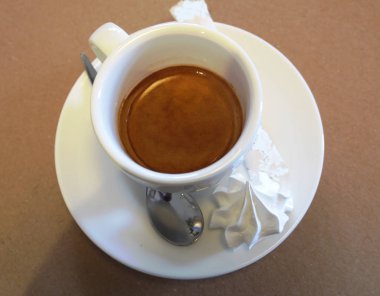 Bir fincan kahve ile krema, şeker ve bisküvi