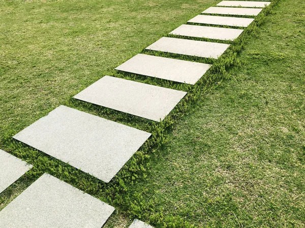 Betonové dlaždice na trávě — Stock fotografie
