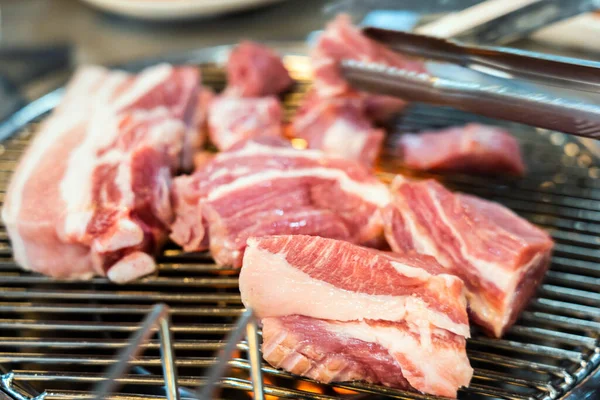 Preparing Traditional Korean Barbecue Grill Pork. Closeup View of Grilling Fresh Raw Meat.