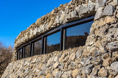 Modern Kamu Mimarisi 'ne Kapalı. Taştan yapılmış eğimli duvar. Kaya Kulübesi.