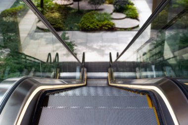 Arka plandaki Odaklı Bahçe Bahçesinde Bulanık Değil. Yürüyen merdiven Yeşil Batık Plaza 'ya iniyor. Teknoloji ve Doğa.