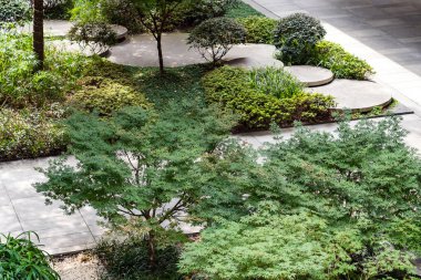 Küçük Bahçede Yuvarlak Beton Merdivenler. Çalılıklar ve Ağaçlar Arasındaki Yol 'un Üst Manzarası. Sürdürülebilir Yeşil Mimarinin Peyzaj Tasarımı. Yeşillikte Basamak Taşları.