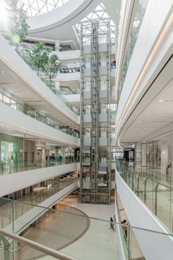 ŞANGHAI, ÇİN - 10 Kasım 2018. New Shopping Mall LuOne Shanghai 'ın Atriyumunda panoramik yükselmeler. Beyaz Perakende İç Tasarım Cam Asansörleri.