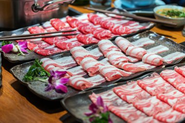 Biftek, kuzu eti ve domuz eti de dahil olmak üzere et tabağı seçimi. Hızlı pişirmek için ince dilimlenmiş. Sos ve esrar arka planda