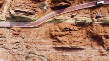 Gökkuşağı Dağları Jeoloji Parkı 'nın en iyi manzarası. Stripy Zhangye Danxia Landform Jeoloji Parkı, Gansu Eyaleti, Çin. Güneşli bir günde, bir vadideki yolda uçan turist otobüslerinin robot resmi..