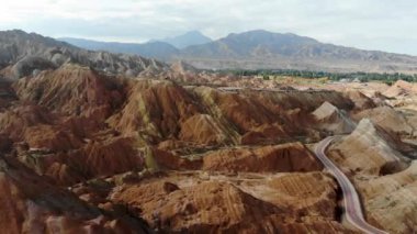 Gökkuşağı Dağları Jeolojik Parkı 'nın Havadan Görünümü. Stripy Zhangye Danxia Landform Jeoloji Parkı, Gansu Eyaleti, Çin. Güneşli bir günde Vadi 'de Yoldaki Turist Otobüslerinin Uçan Drone Resimleri.