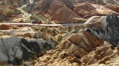 Gökkuşağı Dağları Jeolojik Parkı 'nın Üst Hava Manzarası. Stripy Zhangye Danxia Landform Jeoloji Parkı, Gansu Eyaleti, Çin. Güneşli bir günde Vadi 'de Yoldaki Turist Otobüslerinin Uçan Drone Resimleri.