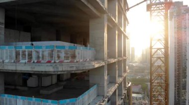 İşçi İnşaat Alanına Cam Pencere Paneli Kuruyor. Perde Duvarları 'nın yanındaki binanın kaplaması. Yüksek Doğulu Günbatımı Binası.