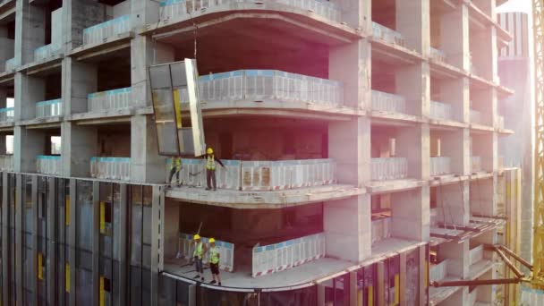 Workers are Installing the Precast Glass Panel on The Construction Site. Cladding of the Building by Curtain Walls. — Stock Footage Workers Installing Precast Glass Panel Construction Site Cladding Building Curtain Stock Footage