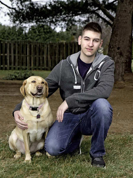 Senior High School male with his yellow Labrador Dog outdoors — Stock Photo, Image