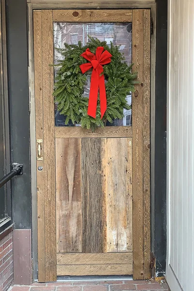 Rustikální Dřevěné Vstupní Dveře Zdobené Vánocům Čerstvým Borovým Věncem Červenou — Stock fotografie
