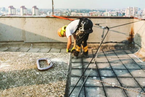 Ouvrier d'accès à la corde industrielle accroché au bâtiment tout en peignant le mur extérieur de la façade. Image concept d'alpinisme industriel. Vue du dessus — Photo