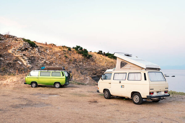 Ormos Panagias, Greece, 28/06/2019: Classical vintage recreational vehicles parked on the beach by the sea. Camper lifestyle