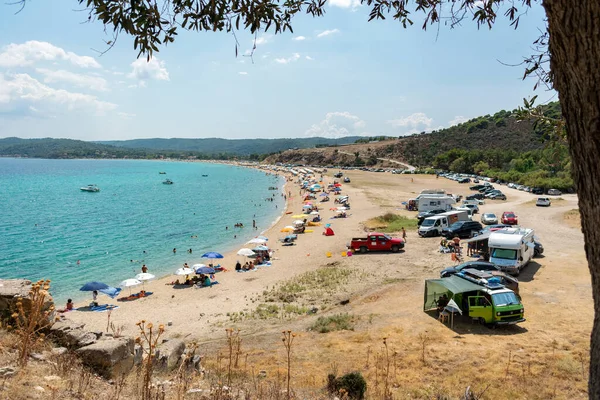 Ormos Panagias, Yunanistan, 29 / 06 / 2019: Deniz kenarında sıcak bir yaz günü. İnsanlar sahilde sıcak havanın tadını çıkarıyorlar ve karavanlarında kıyıya park ediyorlar..
