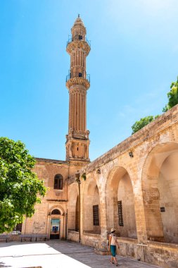 Mardin 'deki antik cami bahçesinde yürüyen genç bir kız.