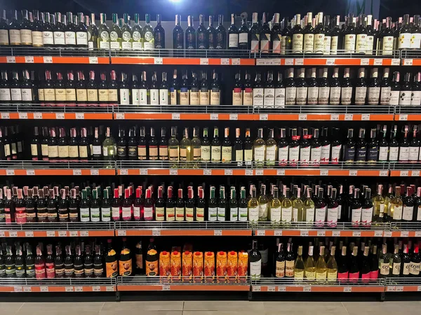Butelki wina zbliżenie na półkach w supermarkecie — Zdjęcie stockowe