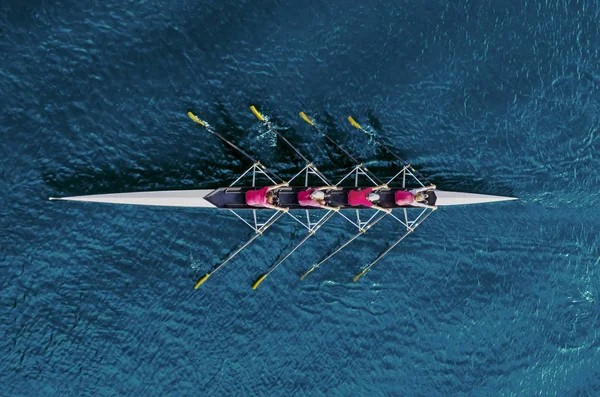 Squadra voga femminile sull'acqua blu — Foto Stock