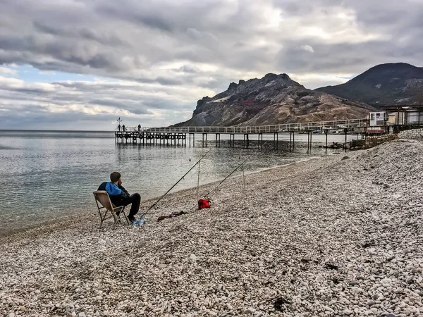 Pescatore pesca sulla costa del Mar Nero a Koktebel in C — Foto Stock