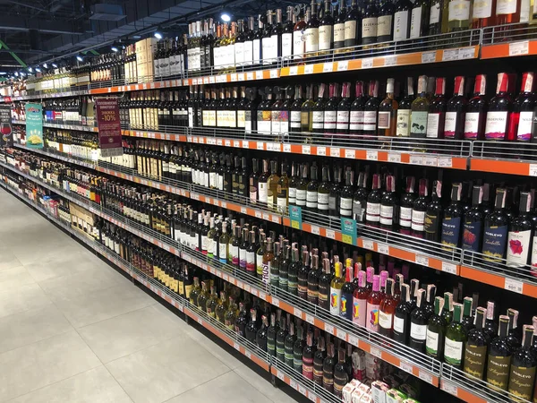 Duża liczba butelek wina leżących w gablocie w super — Zdjęcie stockowe