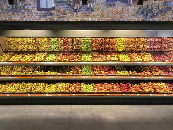 Różne jabłka leżące w gablocie w supermarkecie — Zdjęcie stockowe