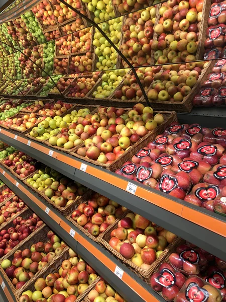 Różne jabłka leżące w gablocie w supermarkecie — Zdjęcie stockowe