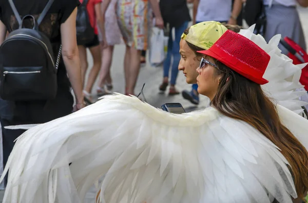 Chica con alas de ángel se sienta en un banco — Foto de Stock