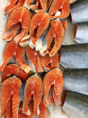 Biftek için kesilmiş taze kırmızı balık parçaları bir vitrinde duruyordu.