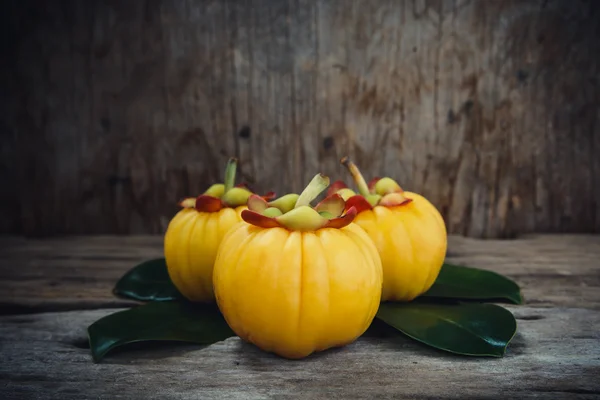 Garcinia cambogia fresh fruit on wood background.  Fruit for diet and good health. — Stock Photo, Image