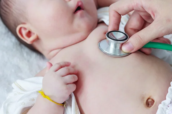 Pediatra examinando infante. Dos meses bebé asiático chica mintiendo —  Fotos de Stock