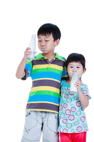 Twee Aziatische jongen en meisje consumptiemelk, geïsoleerd op wit. Het drinken van melk voor een goede gezondheid. — Stockfoto