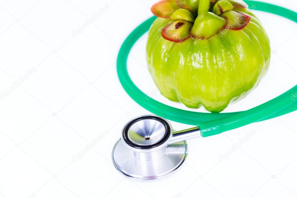 Closeup garcinia cambogia y un estetoscopio sobre fondo Closeup garcinia cambogia y un estetoscopio sobre fondo