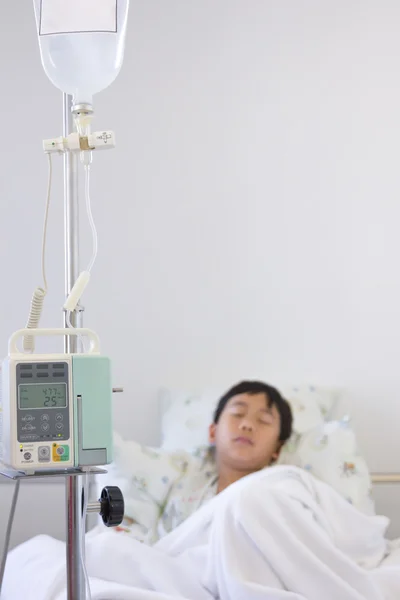 Asiático chico durmiendo en enfermo cama con infusión bomba intravenoso IV goteo —  Fotos de Stock
