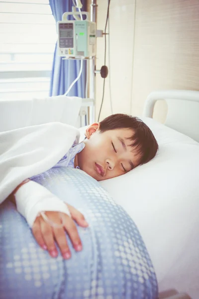 Ασίας αγόρι που βρίσκεται σε sickbed με αλατούχο ενδοφλέβια (Iv). Φροντίδας υγείας και άτομα έννοια. Vintage στυλ. — Φωτογραφία Αρχείου