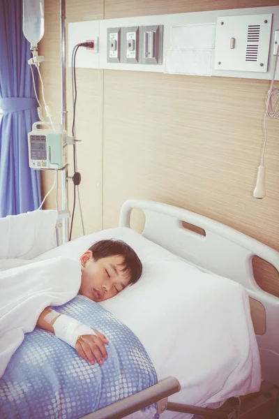Illness asian boy sleeping on sickbed in hospital with infusion pump — Stockfoto