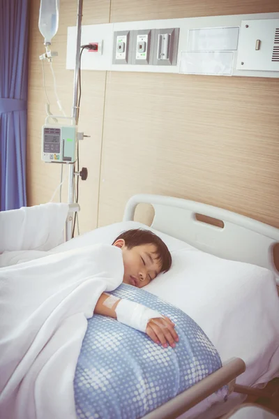 Illness asian boy sleeping on sickbed in hospital with infusion pump intravenous IV drip.