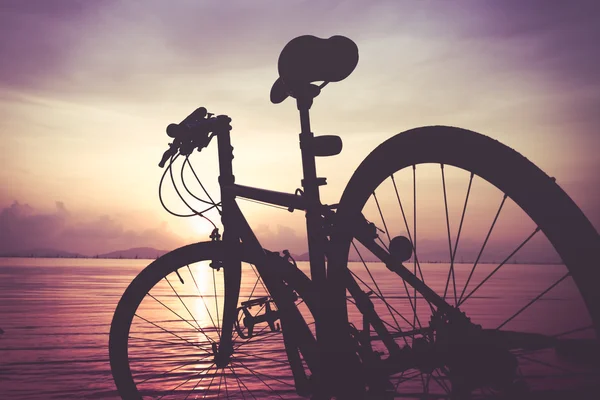 自行车在海对多彩的日落海滩上的剪影 — 图库照片