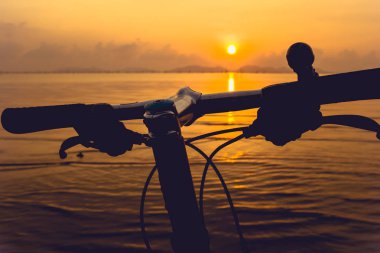 Bir parça Bisiklet gidon sahilde silüeti. Açık havada.