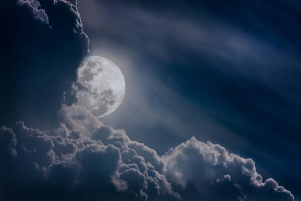 Attractive photo of a nighttime sky with clouds, bright full moon would make a great background. Nightly sky with large moon. Beautiful nature background. Outdoors.