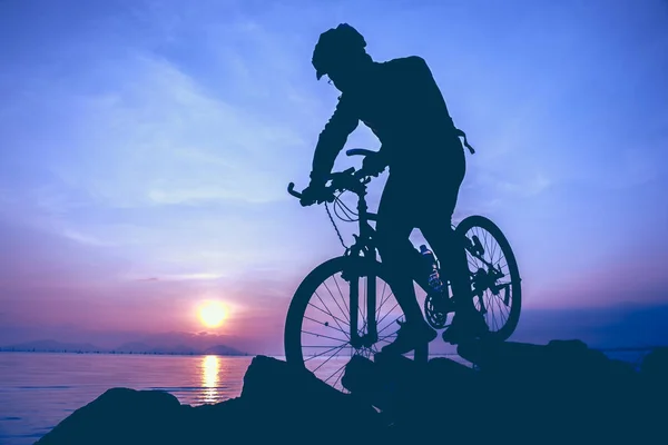 健康的生活方式。自行车骑自行车在海边的剪影. — 图库照片