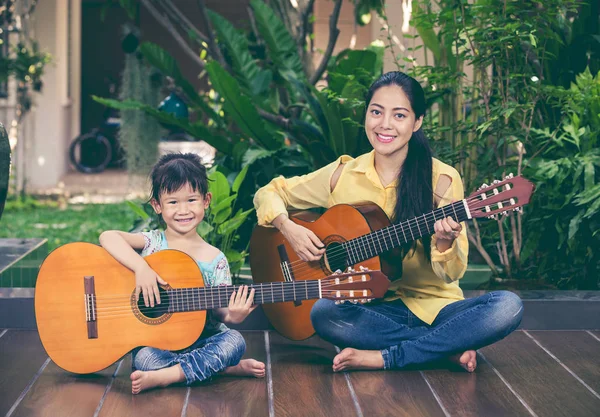 Matka z córka grać na gitarze. Rodzinie spędzać czas razem — Zdjęcie stockowe