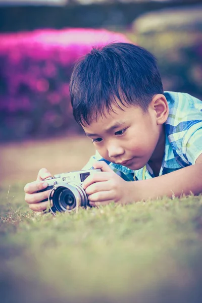 Jongen nemen foto door de camera, het verkennen van de natuur in het park. — Stockfoto