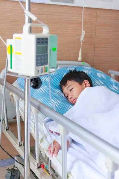 Asijské boy leží na lůžka s infúzní pumpy Iv intravenózně. — Stock fotografie