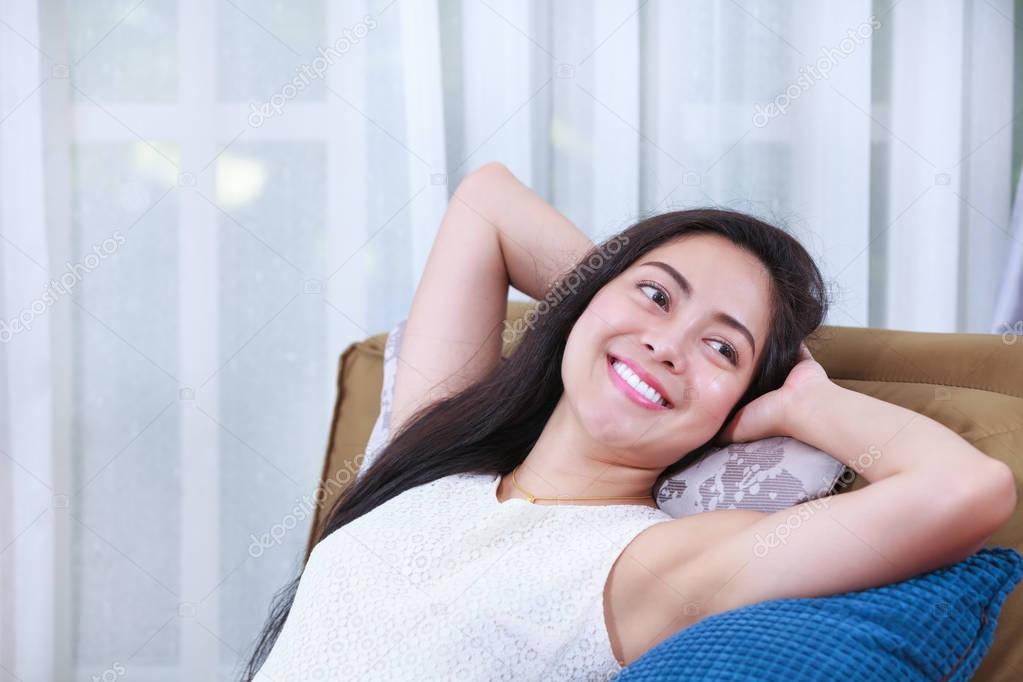 Relaxing woman lie down comfortable and smiling happy at home.